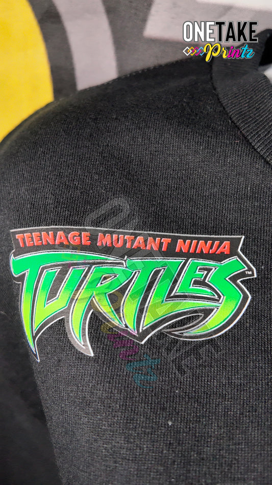 Black shirt with 'Teenage Mutant Ninja Turtles' logo on a dark background